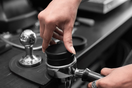 Closed up of baristaâs hand tamping the portafilter before making fresh coffee in a coffee shop.の写真素材