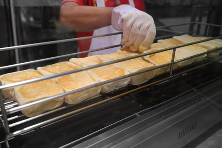 Pastry chef toasting bread on iron griddles. Preparing food process for customers