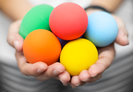 Closed up of  womanâs hands holding colorful Easter eggs. Easter festival conceptの写真素材