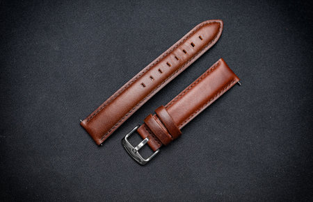 Luxury, minimalist brown tanned leather watch strap on a black surface background.の写真素材