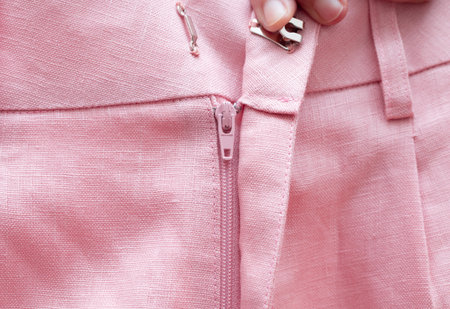 Street style fashion linen shorts close-up, classic summer style outfit, warm pink colors.の写真素材