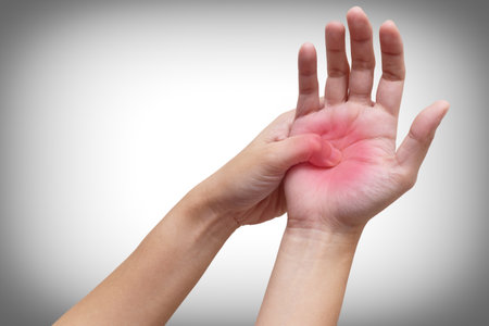 Woman holding her hand with acute pain in palm isolated on white background. Medical treatment and pain concept. Color Manipulation image to emphasize the pain.の写真素材