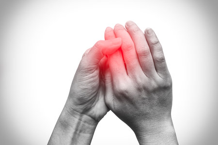 Woman hands holding isolated on white background with red spot on finger pain. Black and white tone. Healthcare problem. Pain and infection.の写真素材