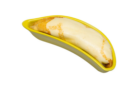 Cold crepes filled with banana are arranged in a yellow banana shaped ceramic plate. isolated on whiteの写真素材