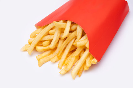 French fries in red paper bucket isolated on white background with shadowの写真素材