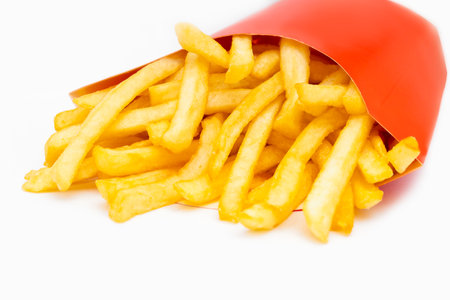 Close-up of french fries in red paper bucket isolated on white background with shadowの写真素材