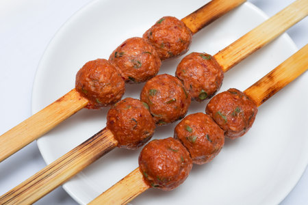 Grilled Thai fish cake prick with skewer serving on white plate, local Thai traditional food conceptの写真素材
