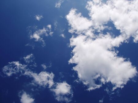 blue summer sky with light white and grey cloudsの写真素材
