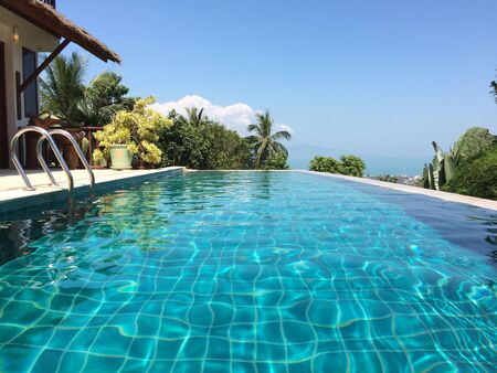Pool on a luxury tropical villa with the palm trees view and sea viewの素材