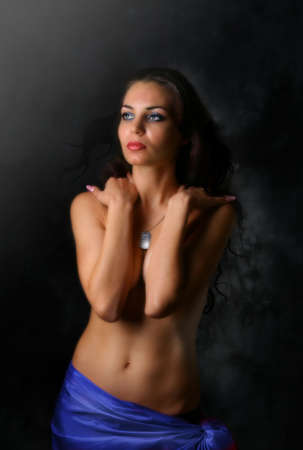 Glamour Girl on dark background in blue silk cover the breastの写真素材