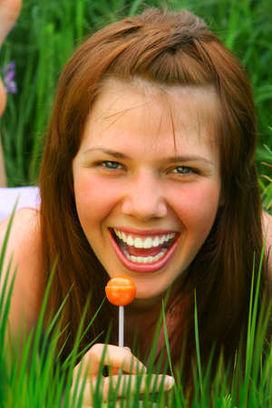 Smiling Girl with orange Lollipopの写真素材