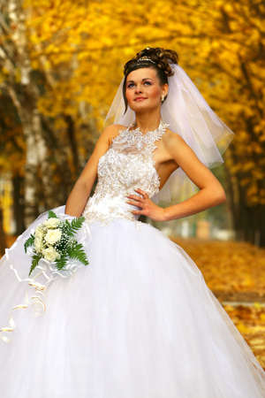 Beautiful Bride posing in autumn parkの写真素材