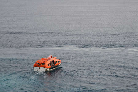 Orange rescue boat or life boat sails on the seaの写真素材