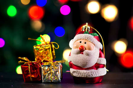Cute Santa Claus with three gift boxes on shiny lighting backgroundの写真素材