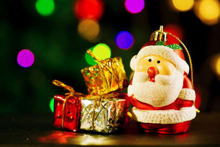 Cute Santa Claus with three gift boxes on shiny lighting backgroundの写真素材