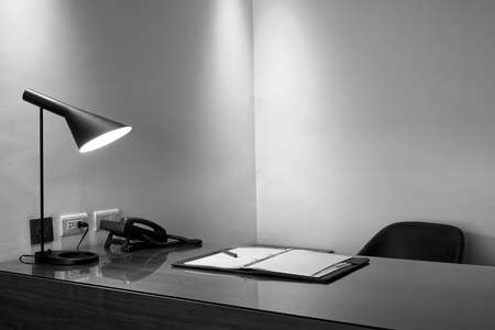Lamp, phone and note book on a desk in a luxury officeの写真素材