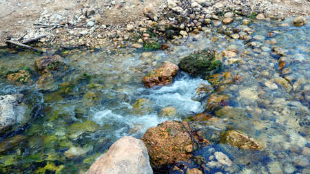 Mountain river, fast flowing water, clear water, white stones at the bottom, many green plants on the shore, high cliffs. Serpis River, Spain.の写真素材