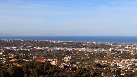 Panoramic view from height of Mediterranean resort seaside town Denia, roofs of the houses, sea in the distance, beautiful landscapeの写真素材