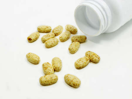 yellow pills on white background close up