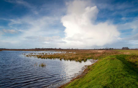 view on horizon between big lake and blue sky with cloudsの写真素材