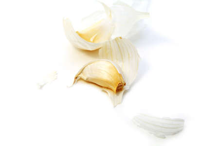 one clove and skin of the garlic bulb on white backgroundの写真素材