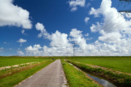 road for bicycles through green pastures and with beautiful skyの写真素材