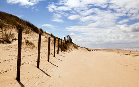 view on  warm sandy beach close to North sea and beautiful blue skyの写真素材
