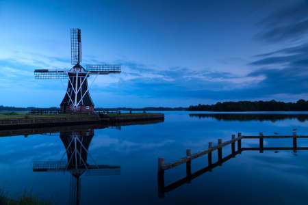 windmill close to lake at sunsetの写真素材