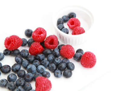 fresh raspberries and blueberries over white