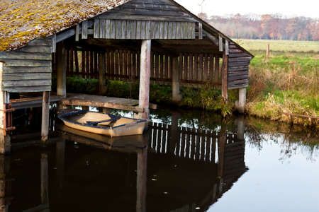 old boat in wooden fisherman hut on waterの写真素材