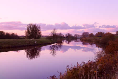 pink sunset over canal in rural farmlandの写真素材
