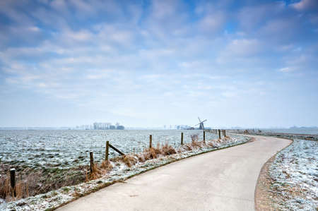 bike road to the windmill in winter, Netherlandsの写真素材