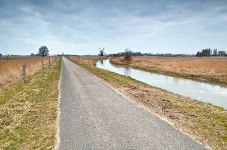 bicycle path and windmill in dutch countryside, Groningenの写真素材