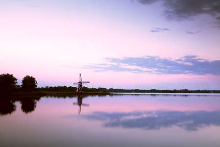 windmill reflection in big lake at sunsetの写真素材