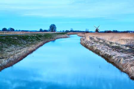 Dutch windmill and river in duskの写真素材