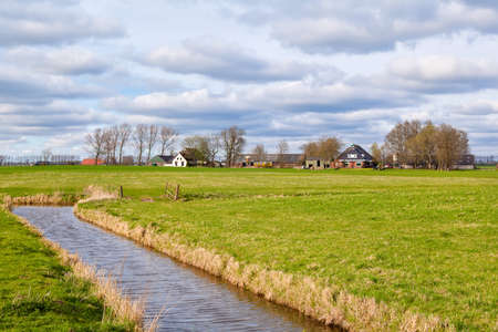 typical dutch farmland with canal, Hollandの写真素材