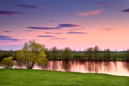 colorful sunset over calm river, Gelderland, Netherlands