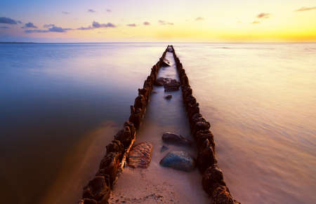 long wooden dike in North sea at sunset, Hindeloopen, Friesland