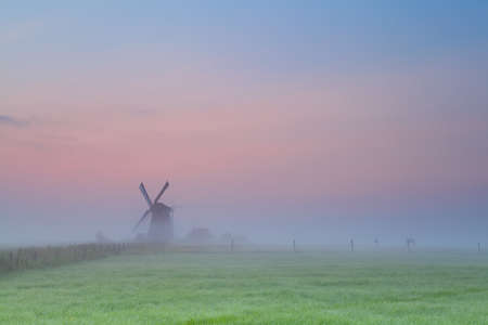 windmill silhouette over sunrise sky, Groningen, Netherlandsの写真素材