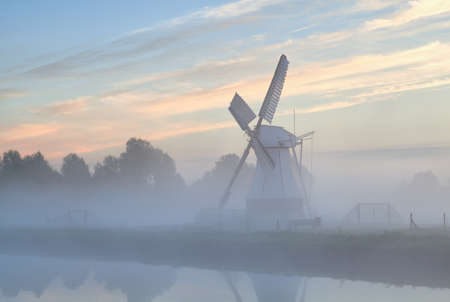Dutch windmill in morning fog at sunrise, Hollandの写真素材