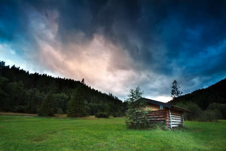 alpine wooden hut during stormy sunset, Bavaria, Germanyの写真素材