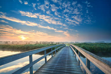 wooden bridge through the river at sunrise, Onlanden, Drenthe, Netherlands