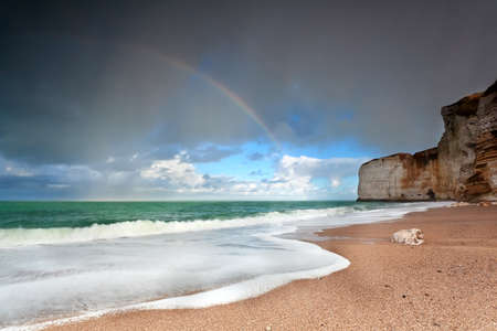 rainbow over ocean coast by cliff, Etretat, Normandy, Franceの写真素材