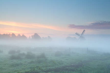 windmill silhouette in dense morning fog, Hollandの写真素材