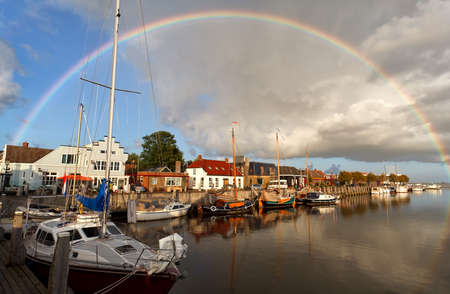 rainbow over harbor in Zoutkamp, Groningen, Netherlandsの写真素材