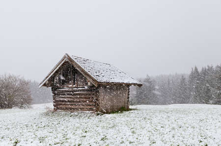 old wooden hut at snowstorm, Bavarian Alps, Germanyの写真素材