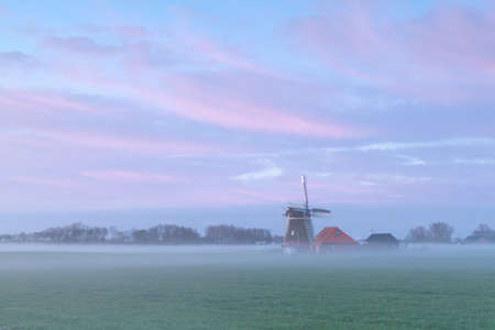 Dutch windmill in foggy sunrise, Hollandの写真素材