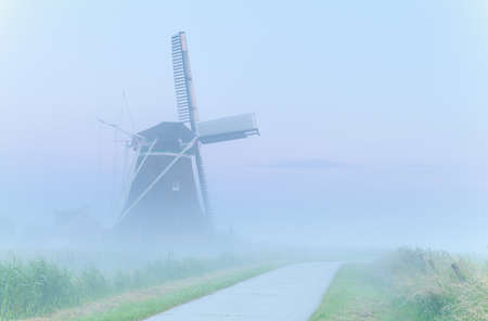 charming windmill in dense fog, Netherlandsの写真素材