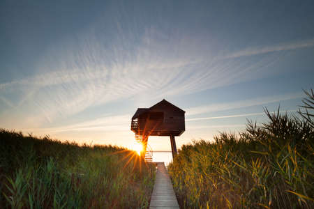 sunbeams behind wooden observation tower, Nieuwe Statenzijl, Netherlandsの写真素材