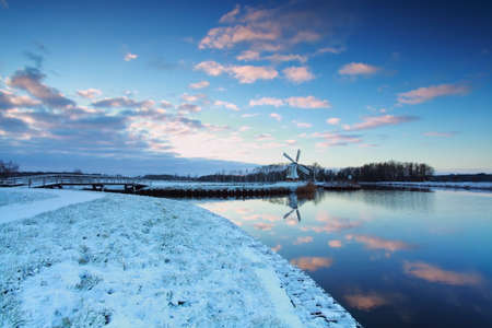 Dutch windmill by canal in winter, Netherlandsの写真素材